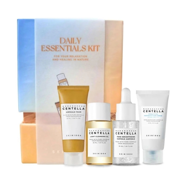 Le coffret Skin1004 Daily Essentials Kit Routine de Soins Complète présente quatre produits de soins de la peau exquis : une mousse en ampoule, une huile nettoyante légère, un sérum et une crème éclaircissante, tous élégamment disposés avant l'emballage du kit. Dakar