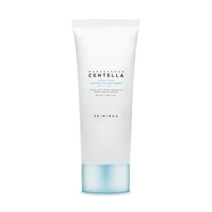 Un tube blanc de crème solaire Skin1004 Madagascar Centella Air-Fit est présenté sur un fond uni. Le texte sur le tube le décrit comme un sérum solaire à l'extrait de Centella. Dakar