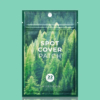 Un sachet vert étiqueté « Spot Cover Patch » avec une image de forêt dense. Ce sachet contient 22 patchs et est de la marque SKIN1004. Le fond est bleu sarcelle uni. Dakar