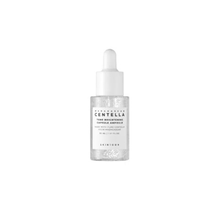 Un flacon transparent d'ampoules éclaircissantes Skin1004 Centella de Madagascar avec un bouchon compte-gouttes blanc. L'étiquette est blanche avec un texte noir, et le liquide transparent à l'intérieur est visible. Dakar