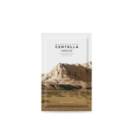 Un emballage de produit de beauté représentant un paysage désertique vallonné et à la végétation clairsemée. L'emballage porte l'inscription « Masque en feuille ampoule à la centella de Madagascar » de « SKIN1004 ». Le design est minimaliste et naturel. Dakar