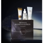 Une boîte noire intitulée « SKIN1004 Ramadan Edition » présente le Coffret Skin1004, contenant un tube beige, un flacon compte-gouttes blanc et un tube blanc. Le fond sombre avec des particules de lumière dispersées renforce son attrait dramatique. Dakar