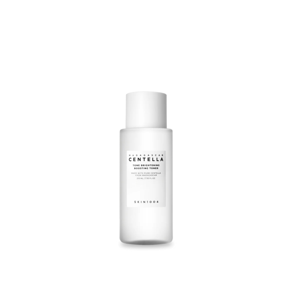 Un flacon blanc de tonique illuminateur SKIN1004 à la centella de Madagascar. L'étiquette présente un texte noir avec le nom et les informations du produit. Le flacon, au design minimaliste, se détache sur un fond blanc. Dakar