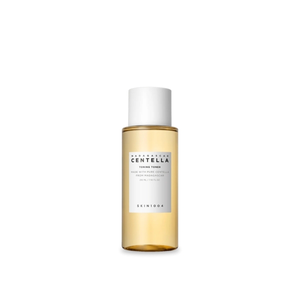Un flacon transparent de lotion tonique à la centella de Madagascar SKIN1004 avec un bouchon blanc. Le liquide à l'intérieur est ambré clair. L'étiquette sur le devant fournit des informations sur la marque et le produit. Le fond est blanc uni. Dakar