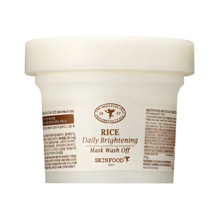 Un contenant blanc de masque éclaircissant quotidien SKINFOOD au riz. L'étiquette présente des textes en anglais et en coréen, un logo marron et des éléments décoratifs. Le contenant est simple et présente une finition lisse et mate. Dakar