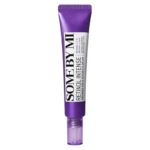 Un tube violet de crème contour des yeux triple action intense au rétinol de SOME BY MI. Le tube est doté d'une étiquette blanche avec un texte en noir et blanc détaillant le nom et les bienfaits du produit. Dakar