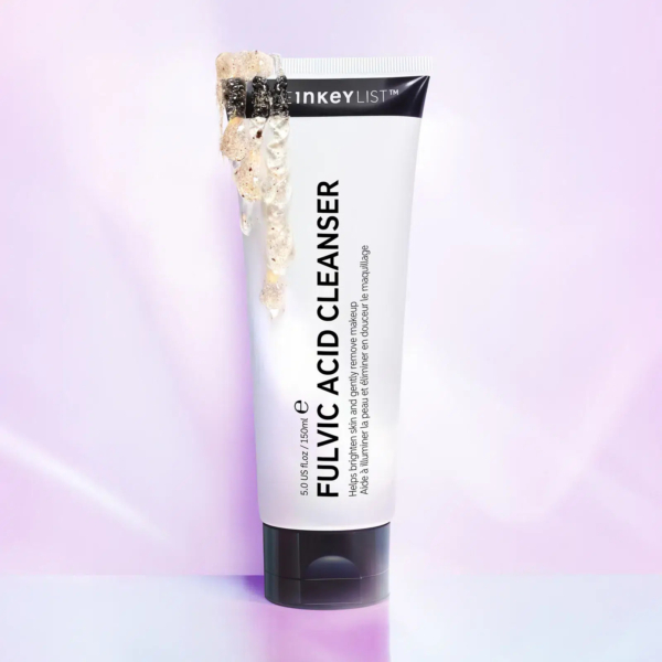 Tube de nettoyant à l'acide fulvique avec bouchon noir et bouchon déverseur. L'étiquette du tube est noire sur fond blanc. La marque n'est pas clairement visible. Le fond présente une légère teinte rosée. Dakar