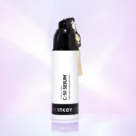 Un flacon de sérum C-50 de The Inkey List sur fond violet doux. Le flacon pompe noir laisse apparaître du sérum sur le côté. L'étiquette indique « Sérum C-50 », soulignant son efficacité pour traiter les imperfections et les boutons. Dakar
