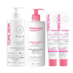 Quatre produits de soin Topicrem sont présentés : le Lait Corps Ultra-Hydratant, le Lait Ultra-Hydratant MELA et deux crèmes Hydra+ Légère Éclat. Les flacons et tubes, aux touches de rose, sont étiquetés pour l'hydratation et les peaux sensibles. Dakar
