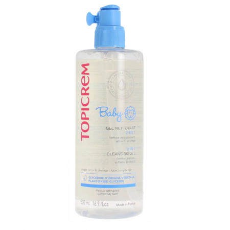 Un flacon transparent de gel lavant Topicrem pour bébé avec une pompe bleue. L'étiquette est ornée d'un texte rouge et bleu, avec un petit visage de bébé. Ce flacon de 500 ml est fabriqué en France. Dakar