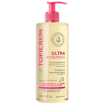 Un flacon d'huile de douche ultra hydratante Topicrem à l'huile d'olive et à la glycérine, conçue pour les peaux sensibles. Le flacon transparent est doté d'un bouchon rose et d'un texte rose et noir. Il contient 500 ml et est fabriqué en France. Dakar
