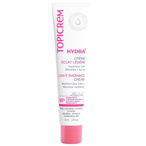 Un tube blanc de Topicrem Hydra+ Crème Éclat Légère. Son bouchon et son texte sont roses, avec des informations en anglais et en français. Cette crème est destinée aux peaux sensibles, normales à mixtes, et promet une hydratation 24 heures. Dakar