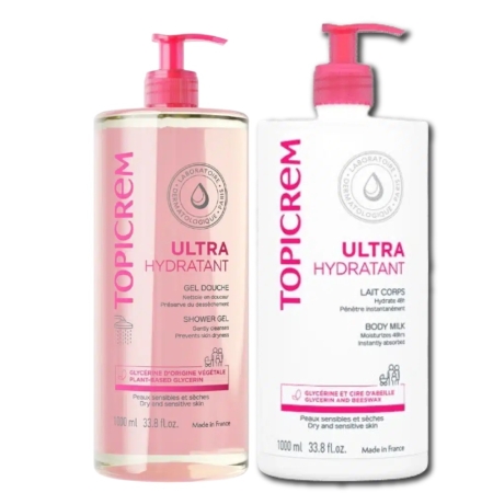 Deux flacons de produits Topicrem Ultra Hydratant. À gauche, un gel douche avec inscription et pompe roses, et à droite, un lait corporel avec inscription et pompe rouges. Les deux flacons font 1 000 ml et arborent un logo en forme de goutte. Dakar