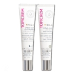 Deux tubes étiquetés « Topicrem ». Le tube de gauche est « Crème de Nuit Peeling Douceur Anti-Taches » et celui de droite est « Crème de Jour Unifiante Anti-Taches ». Les deux tubes ont un fond blanc et un texte rose. Dakar