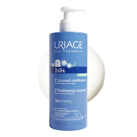 Flacon bleu de Liniment Oléothermique Uriage Bébé 1er. L'étiquette est ornée de fleurs blanches et d'un texte indiquant son utilisation pour les soins de bébé. Contient 92 % d'ingrédients d'origine naturelle, pour un volume de 500 ml. Dakar