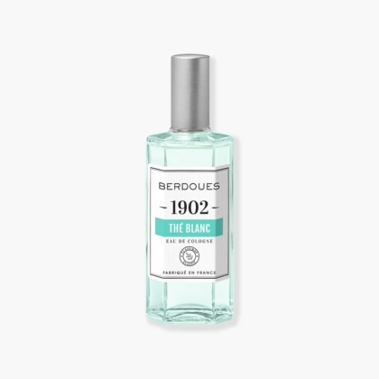 Un flacon en verre transparent de BERDOUES 1902 L'Eau de Cologne Blanche, orné d'un bouchon argenté et étiqueté en blanc avec un texte noir et vert, met en valeur avec élégance son charme sur un fond clair, évoquant une essence intemporelle. Dakar