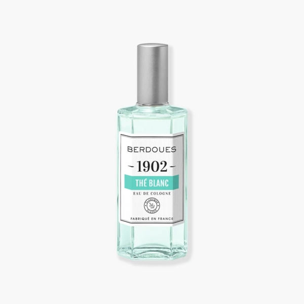 Un flacon en verre transparent de BERDOUES 1902 L'Eau de Cologne Blanche, orné d'un bouchon argenté et étiqueté en blanc avec un texte noir et vert, met en valeur avec élégance son charme sur un fond clair, évoquant une essence intemporelle. Dakar