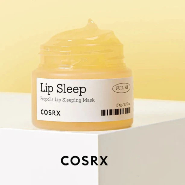 Un pot de masque de nuit pour les lèvres COSRX Lip Sleep Propolis, étiqueté « Full Fit », à la texture jaune crémeuse. Le pot est posé sur une surface blanche, avec le nom de la marque COSRX inscrit en dessous. Dakar