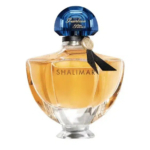 Un flacon de parfum étiqueté « Shalimar » au design élégant et facetté. Il contient un liquide ambré et est doté d'un bouchon bleu bombé et d'un ruban noir décoratif autour du col. Dakar