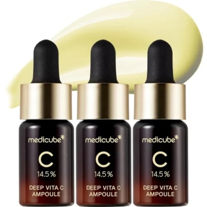 Trois flacons en verre foncé avec compte-gouttes dorés, étiquetés « Medicube Deep Vita C Ampoule 14,5% », sont alignés sur une tache jaune clair du produit, une correspondance parfaite avec l'éclat radieux du Medicube Sérum Éclaircissant Avancé Vitamine C Pure x10 ml. Dakar