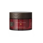Un pot rouge avec un couvercle marron foncé étiqueté « The Ritual of Ayurveda Crème pour le corps rechargeable 220 ml », contenant de l'huile de rose indienne et d'amande douce, rappelant le soin nourrissant de Vaseline Intensive Care™ Mature Skin Rejuvenation. Dakar
