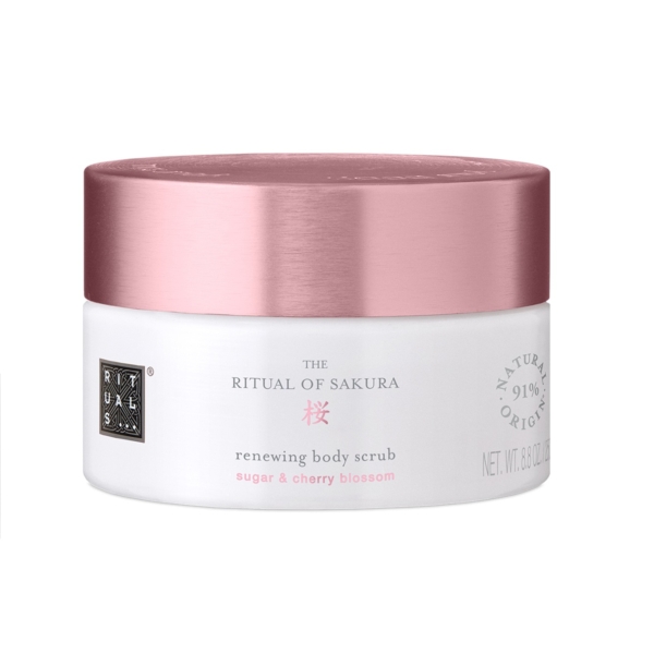 Un pot blanc avec un couvercle rose métallisé étiqueté « Rituals The Ritual of Sakura 250g », inspiré de Tree Hut Coco Colada, contient 8,8 oz et est composé à 91 % d'ingrédients d'origine naturelle. Dakar