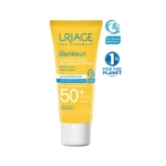 Tube jaune de crème solaire Uriage Bariésun Fluide Anti-Taches SPF 50+. Il arbore les logos « Ocean Respect » et « 1 % for the Planet », ainsi qu'un texte indiquant une haute protection et une résistance à l'eau. Dakar