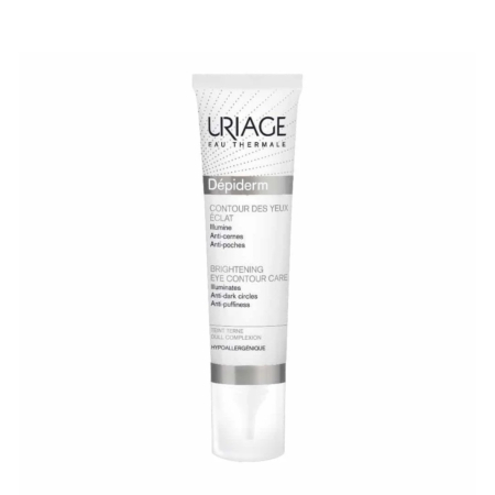 Un tube blanc et argent d'Uriage Dépiderm Soin Contour des Yeux Éclat. Son emballage, en français et en anglais, souligne son efficacité pour illuminer et atténuer les cernes et les poches. Dakar