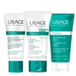 Trois produits de soin Uriage sont présentés : la crème Hyseac 3-Regul Soin Global, la crème solaire Hyseac Fluide SPF 50+ et le Gel Nettoyant Hyseac. Chaque tube arbore un design unique avec des touches de vert et du texte sur fond blanc. Dakar