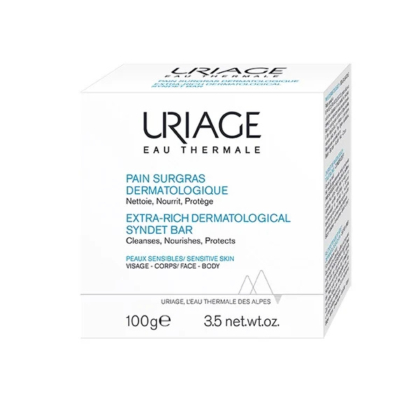 Emballage du Pain Dermatologique Extra-Gros Uriage Eau Thermale. Texte en français et en anglais mettant en avant ses fonctions : nettoie, nourrit, protège. Conçu pour les peaux sensibles du visage et du corps. Poids net : 100 g. Dakar