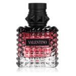 Un flacon de parfum Valentino en verre texturé et clouté. Le flacon est principalement transparent, passant du noir au rose sur le dessus. Il est doté d'un bouchon noir clouté. L'étiquette porte l'inscription « Valentino » en lettres blanches sur fond rose. Dakar