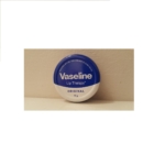 Une petite boîte ronde de Vaseline Lip Therapy Original 17g, avec un couvercle bleu et blanc, est placée sur un fond beige uni. Dakar