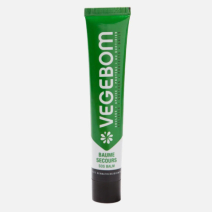 Tube vert avec bouchon blanc étiqueté « Vegebom », avec les mentions « Baume Secours » et « Baume SOS ». Le design comprend un logo floral et un texte descriptif sur les bienfaits dermatologiques. Dakar