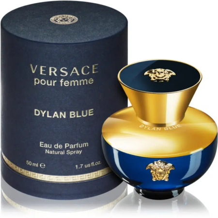 Un flacon d'Eau de Parfum Dylan Blue de Versace pour femme est présenté à côté de son coffret cylindrique. Le flacon est bleu avec un bouchon doré orné de l'emblématique logo Medusa de Versace. L'emballage est bleu marine avec des lettres dorées. Dakar