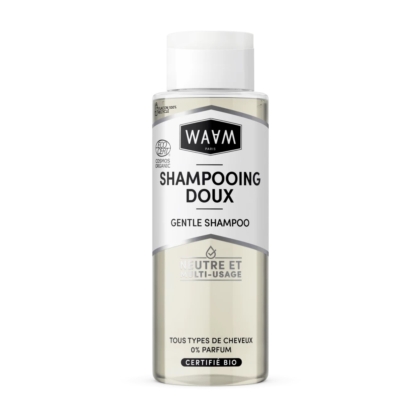 Un flacon transparent de shampoing doux WAAM Paris avec un bouchon argenté. L'étiquette, en français et en anglais, souligne sa certification biologique et son adéquation à tous les types de cheveux. Le texte indique sa neutralité et sa polyvalence. Dakar