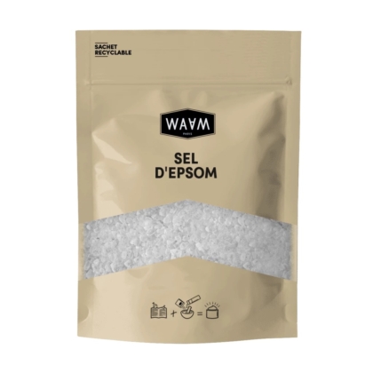Un emballage beige étiqueté « Sel d'Epsom » de WAAM Paris, avec une section transparente laissant apparaître du sel d'Epsom blanc à l'intérieur. L'emballage mentionne le caractère recyclable du produit et comporte de petites icônes d'utilisation suggérées en bas. Dakar