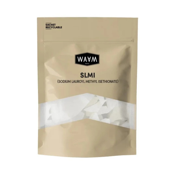 Sachet beige refermable, étiqueté « WAAM SLMI (Sodium Lauroyl Methyl Isethionate) », avec une section transparente laissant apparaître des particules blanches à l'intérieur. Le coin supérieur gauche indique que l'emballage est recyclable. Dakar
