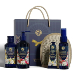 Un coffret de produits Yves Rocher comprenant un lait pour le corps, un gel douche et une crème pour les mains, présentés dans un emballage bleu à motifs floraux. Ils sont présentés avec un accessoire en osier et un sac cadeau bleu foncé orné du logo Yves Rocher. Dakar