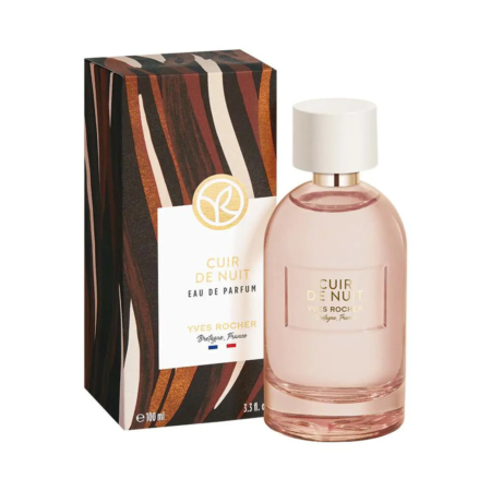 Un flacon en verre de l'Eau de Parfum Cuir de Nuit d'Yves Rocher est posé à côté de son écrin. Le flacon est rose avec un bouchon blanc. L'écrin arbore un motif ondulé marron et beige. Les deux affichent le nom et la marque en lettres dorées. Dakar