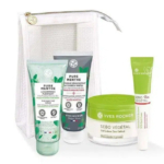 Coffret de soins Yves Rocher comprenant un gommage, un masque au charbon, un gel-crème et un soin ciblé, présentés en tubes et en pot, dans une pochette transparente. L'emballage est vert et blanc, avec des motifs de feuilles. Dakar
