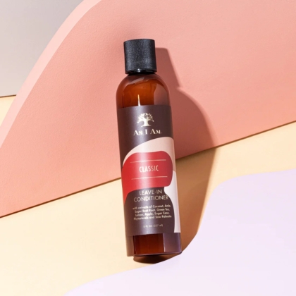 Une bouteille brune d'Asiam Après Shampooing sans Rinçage 237 ml avec un bouchon noir repose sur un fond pastel de surfaces courbes rose doux, pêche et beige. Dakar