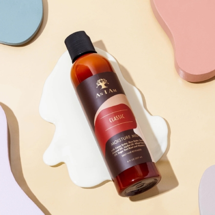 Une bouteille d'Asiam Lait-d'Hydratation 237 ml repose sur une surface beige avec des formes pastel abstraites et un liquide blanc renversé en dessous. Dakar
