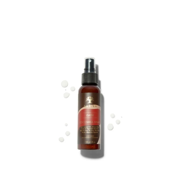 Un flacon pulvérisateur marron étiqueté « Asiam Spray contre la Cocoshea 120 ml » est placé au centre sur un fond blanc, avec de petites gouttes de liquide à proximité. Ce spray hydrate et rafraîchit les cheveux sans rinçage. Dakar