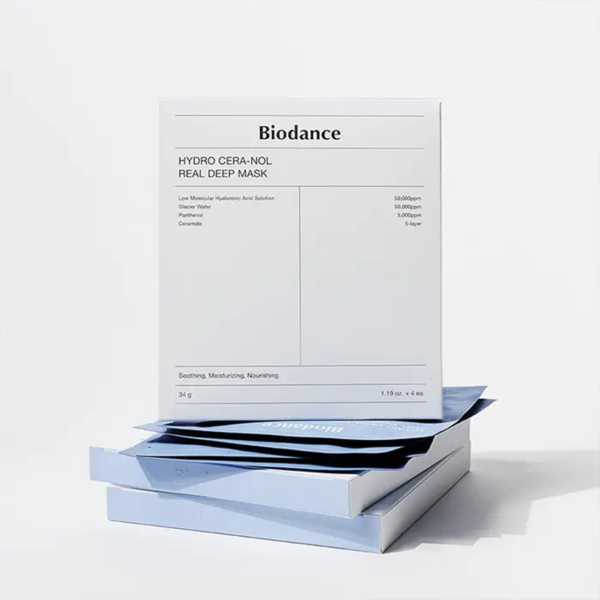 Une boîte blanche intitulée « Biodance Masque Tissu au Collagène Hydro Cera Reel Deep 4 pièces » repose sur plusieurs sachets bleus Biodance Bio Collagène Masque Profond, posés sur un fond uni et clair. Dakar