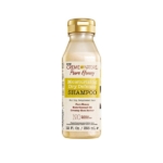 Une bouteille en plastique transparent de 12 fl oz (355 ml) de Crème of Nature Pure Honey Shampooing Hydratant à Base de miel et d'Huile de Noix de Coco avec un bouchon doré, similaire à ASIAM Shampooing Curl Clarity, présente un étiquetage jaune, blanc et marron. Dakar