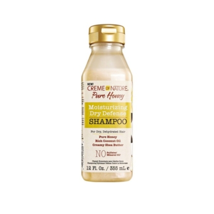 Une bouteille en plastique transparent de 12 fl oz (355 ml) de Crème of Nature Pure Honey Shampooing Hydratant à Base de miel et d'Huile de Noix de Coco avec un bouchon doré, similaire à ASIAM Shampooing Curl Clarity, présente un étiquetage jaune, blanc et marron. Dakar
