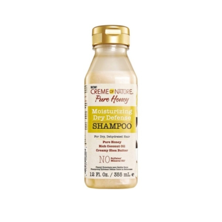 Une bouteille en plastique transparent de 12 fl oz (355 ml) de Crème of Nature Pure Honey Shampooing Hydratant à Base de miel et d'Huile de Noix de Coco avec un bouchon doré, similaire à ASIAM Shampooing Curl Clarity, présente un étiquetage jaune, blanc et marron. Dakar