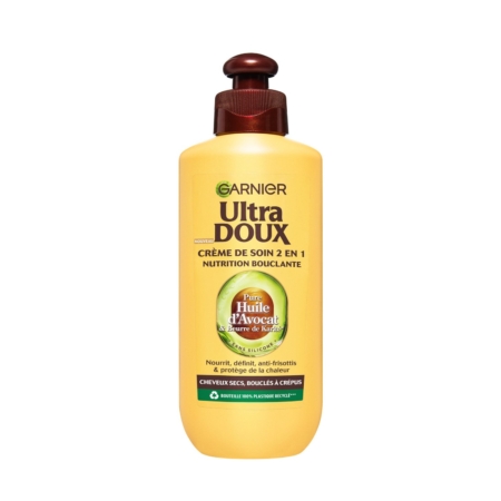 Le flacon jaune de Garnier Crème de Traitement Capillaire sans Rinçage à l'Avocat 200 ml avec une pompe brune, pour cheveux secs ou bouclés, comporte un texte en français mettant en valeur les ingrédients nourrissants que sont l'huile d'avocat et le beurre de karité. Dakar