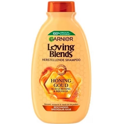 Un flacon de 300 ml de Garnier Shampoing Nourrissant et Réparatrice Loving Blends Miel Or, avec une étiquette en nid d'abeille orange et un texte en français, conçu pour nourrir et réparer les cheveux abîmés. Dakar