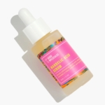 Un flacon compte-gouttes de 30 ml de Good Molecules Sérum Exfoliant Doux à l'Acide Mandélique avec une étiquette rose et multicolore repose sur un fond blanc, projetant une ombre vers la gauche. Dakar